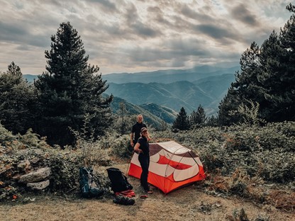twee wandelaars zetten een tent op in de bergen.