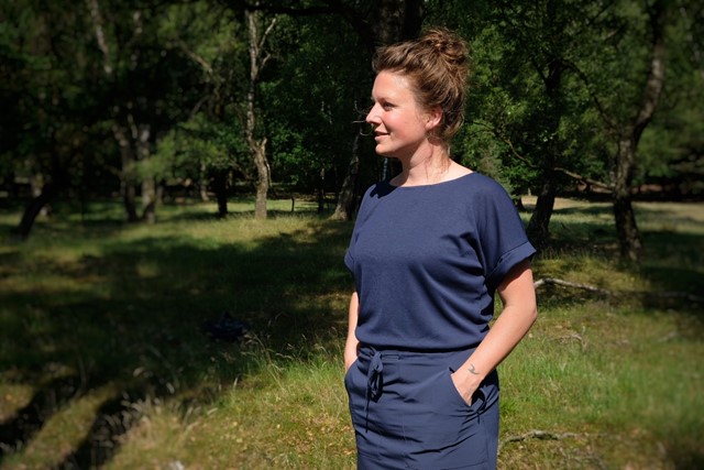 Lizanne in blauwe wandeljurk in de natuur.