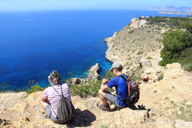 wandelaars rusten uit aan de rotskust van Mallorca.