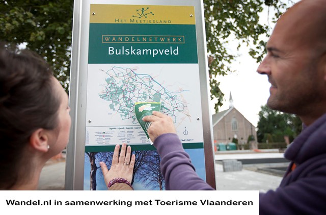 Wandelaars kijken op wandelbord van Bulskampveld
