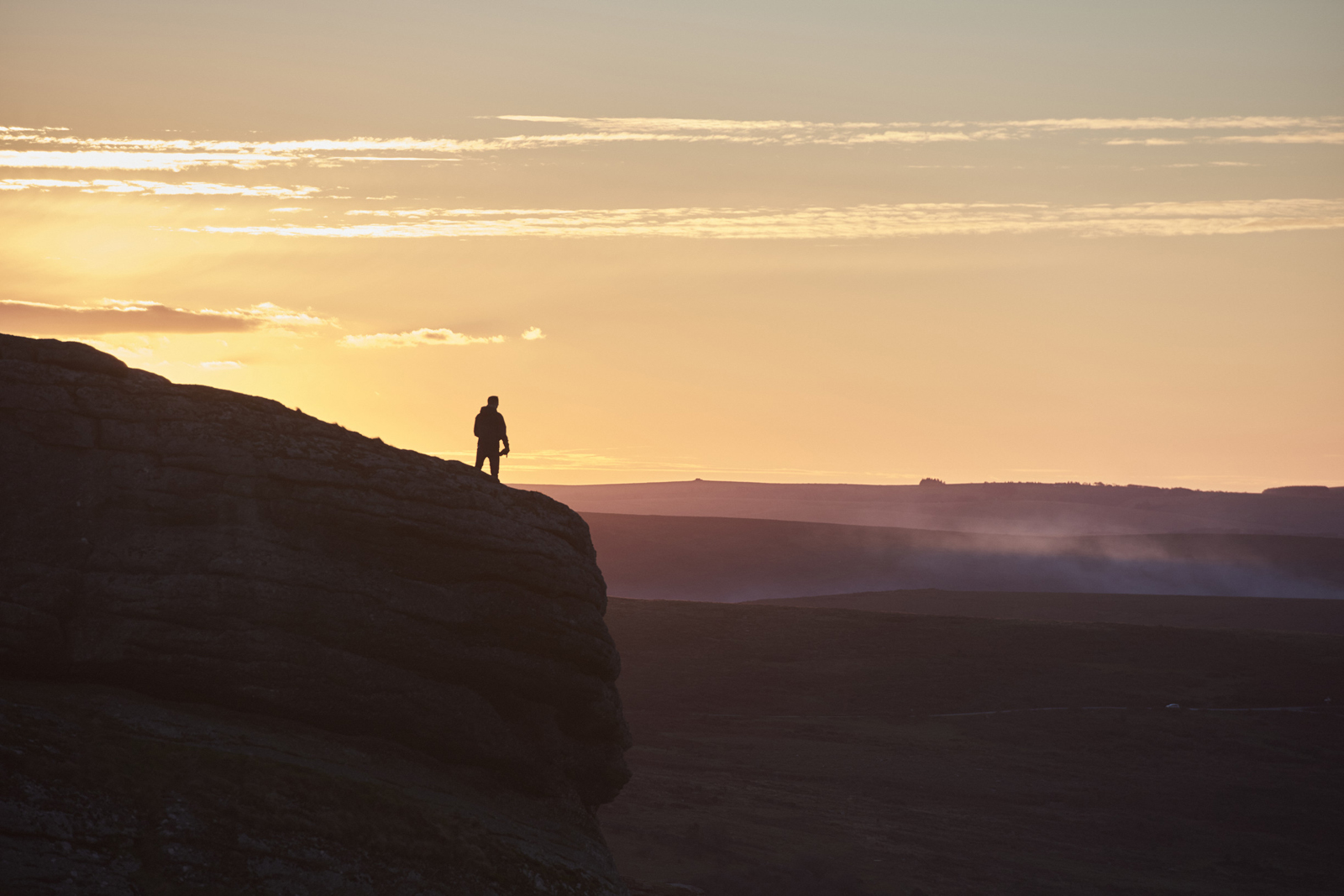 Hiker op de top van een Engelse berg met zonsondergang.