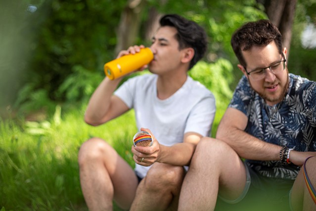 afbeelding van twee mannen die pauze nemen met slok uit een thermosfles.
