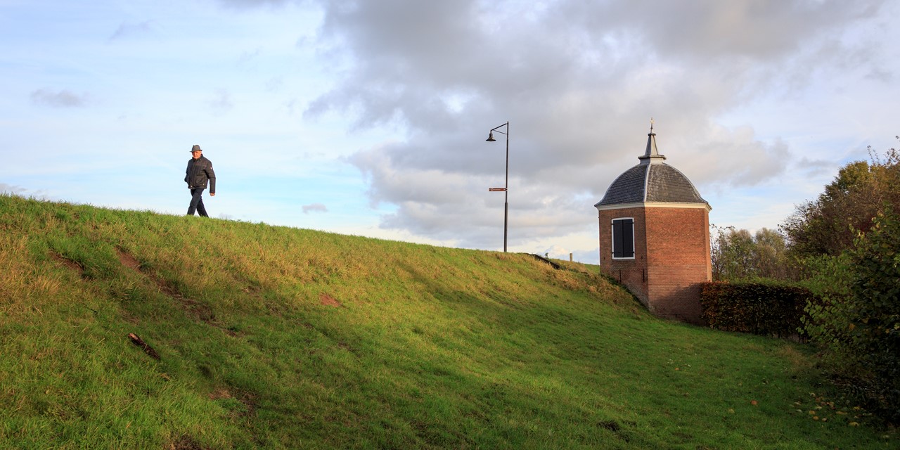 Man lopend op de dijk