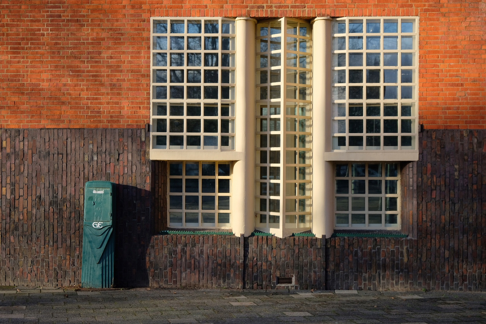 bakstenen gevel met raampartij in de stijl van de Amsterdamse School