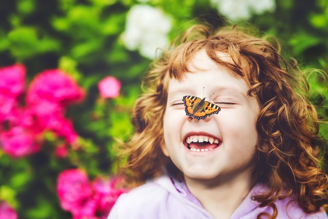 afbeelding van een meisje met een vlinder op haar neus.