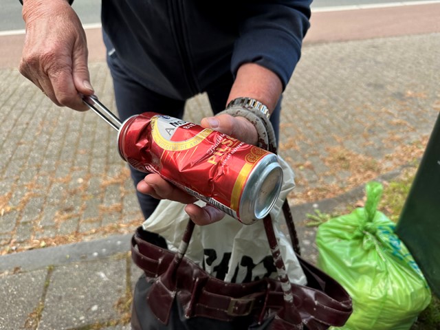 een blikje uitdeuken tijdens het plandelen.