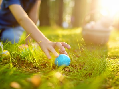 afbeelding van een kind die een paasei raapt.
