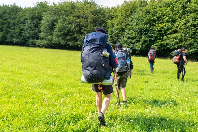 Groep wandelt door weiland met hiking rugzak met bevestiginglussen