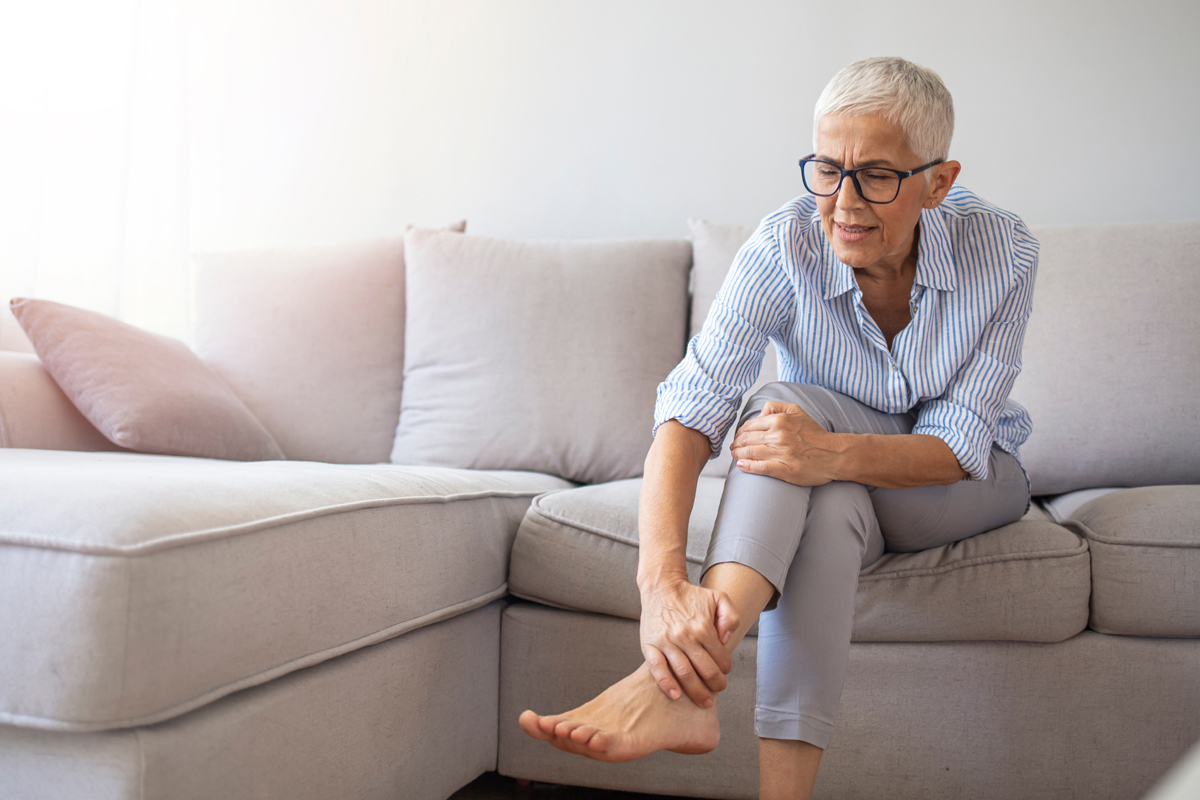 afbeelding van een vrouw die grijpt naar haar voet die pijndoet.