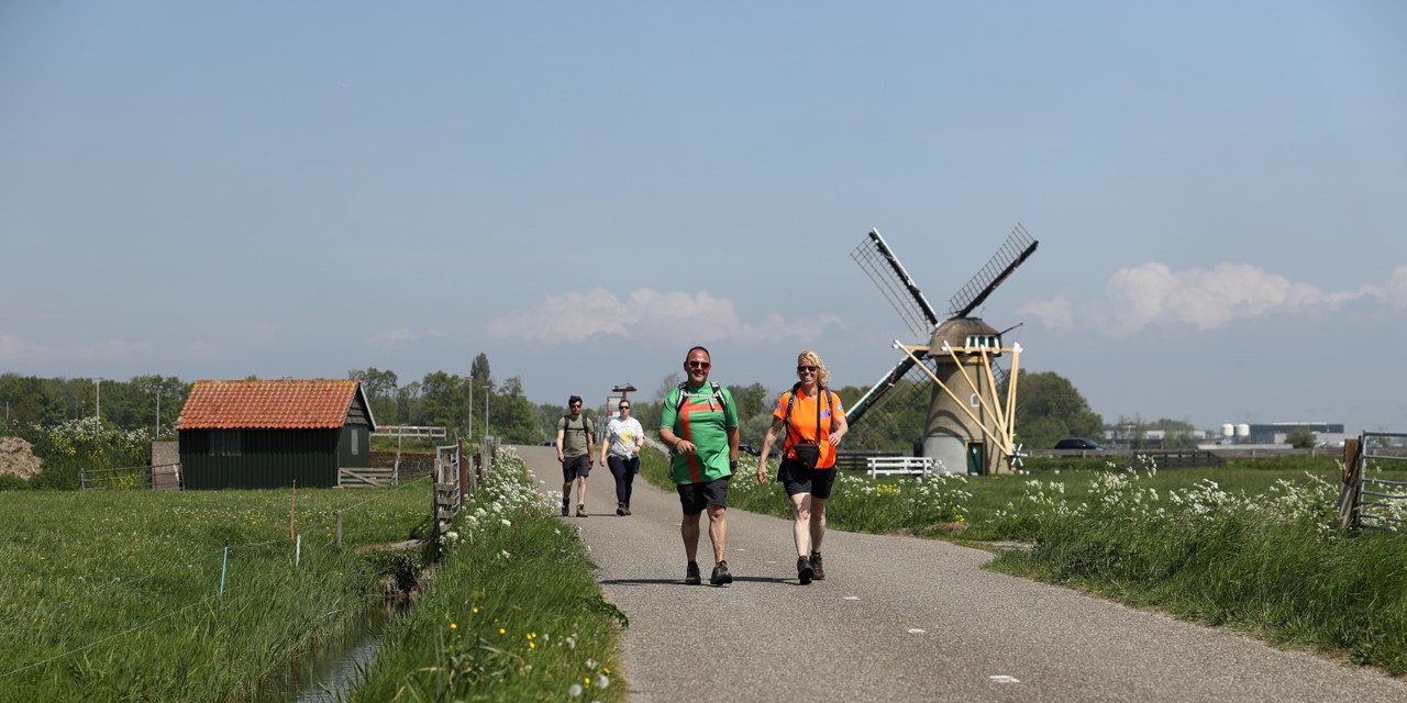 afbeelding van wandelaars en een molen bij Katwijk