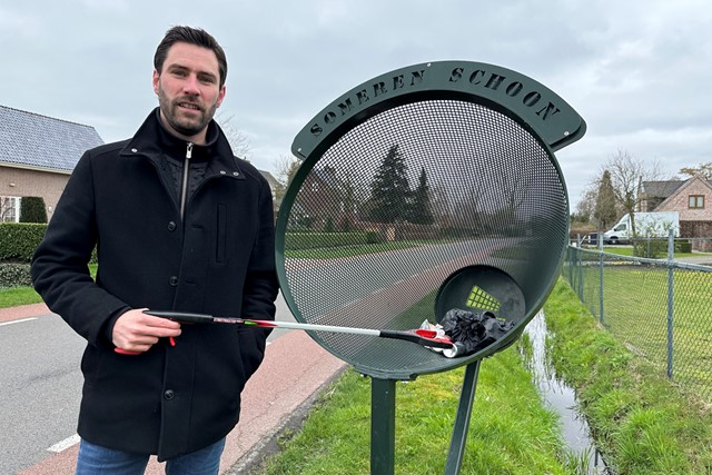man met afvalgrijpstok bij een afvalbak in Someren
