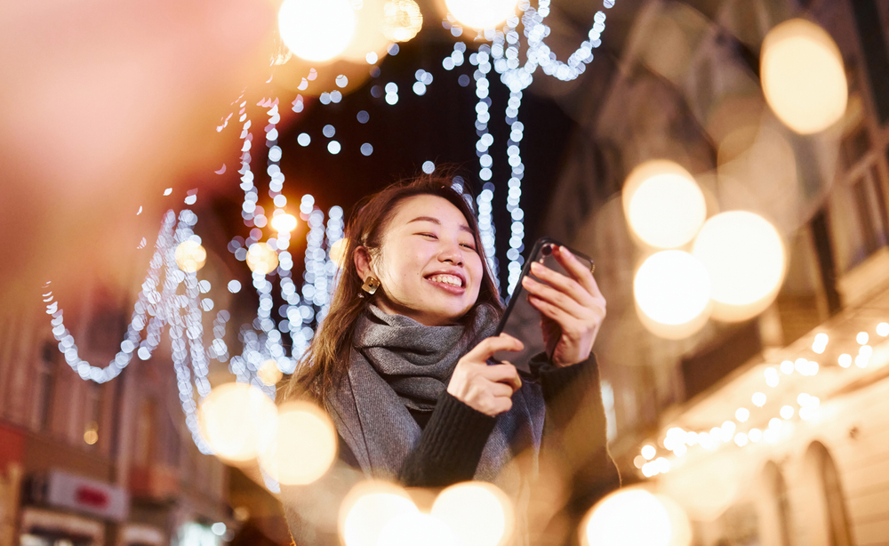 afbeelding van een vrouw temidden van feestelijke lichtjes.