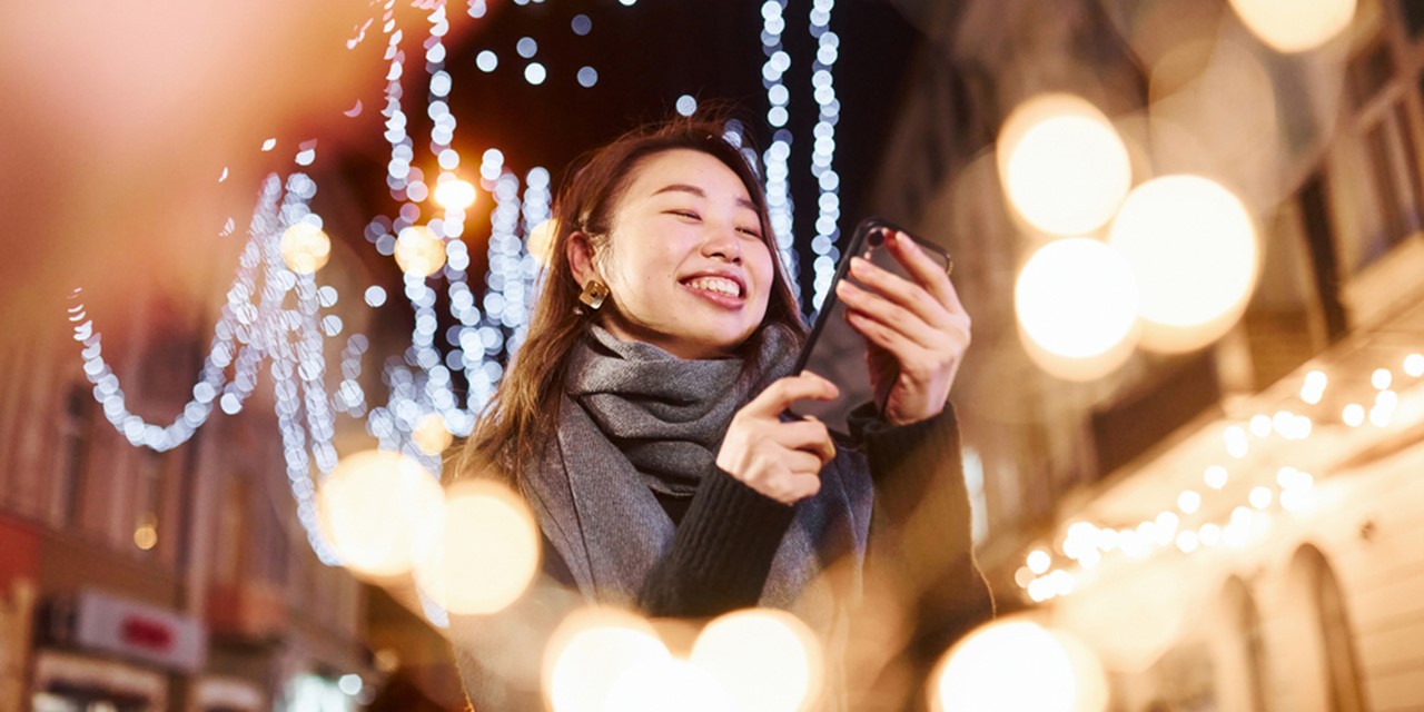 afbeelding van een vrouw temidden van feestelijke lichtjes.