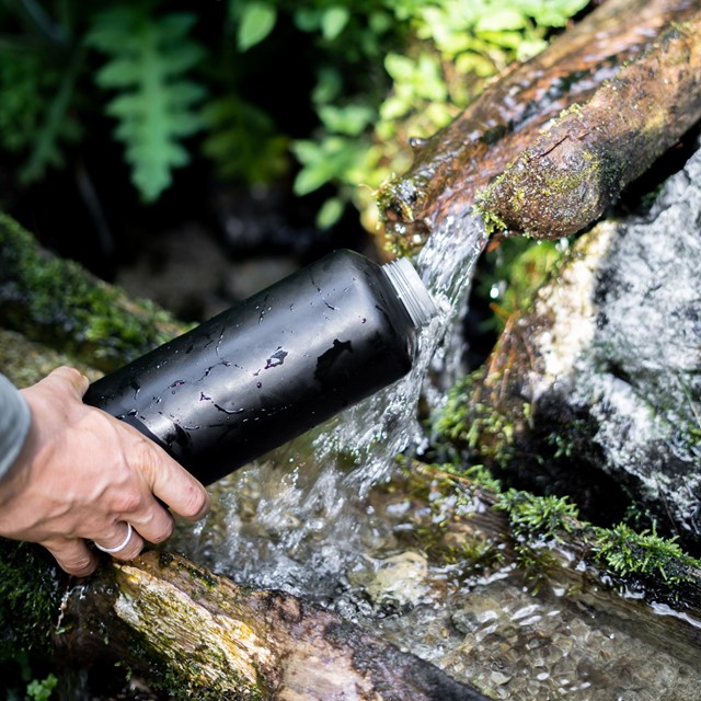 waterfles vullen in de natuur.