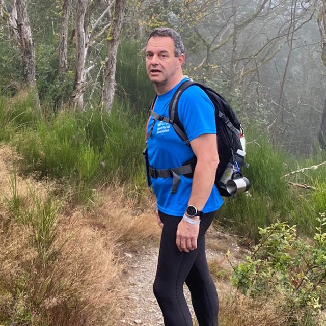 afbeelding van Rino Hamelink die wandelt op een natuurpaadje en poseert.