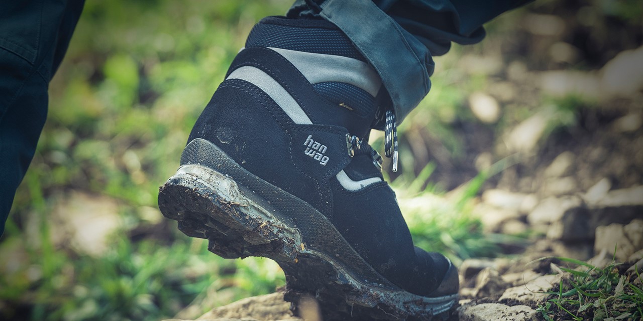 Hanwag schoen op een boomstam.