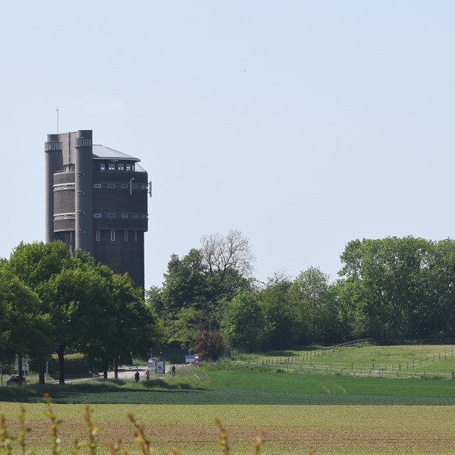 watertoren van Schimmert in een groen landschap met gras en bomen