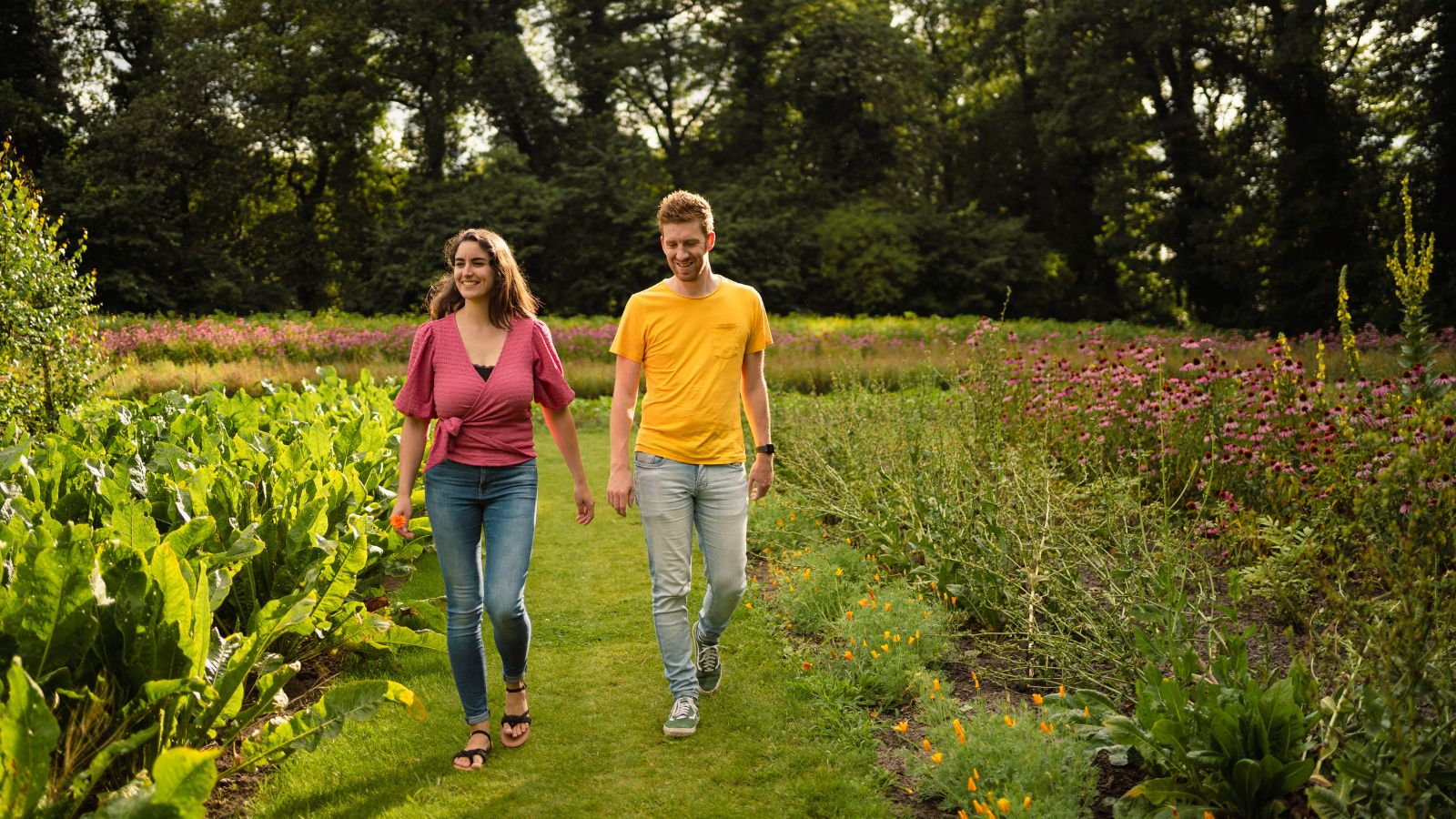 Wandel in en om de A.Vogel tuinen; jong koppel wandelt tussen de kruidenbedden