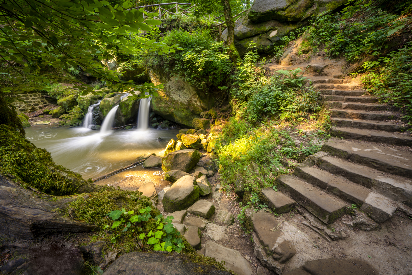 afbeelding van een waterval en trap in de Schiessentümpel in het Mullerthal.