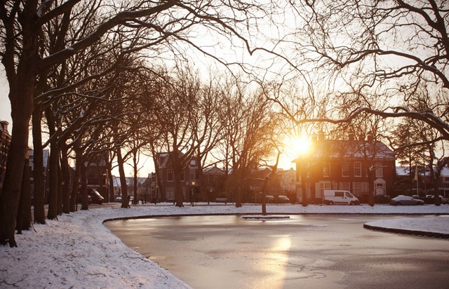 afbeelding van een winterse gracht met sneeuw op het pad ernaast.