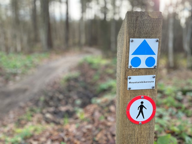 Afbeelding van een paaltje dat aangeeft dat dit een mountainbikeroute is.