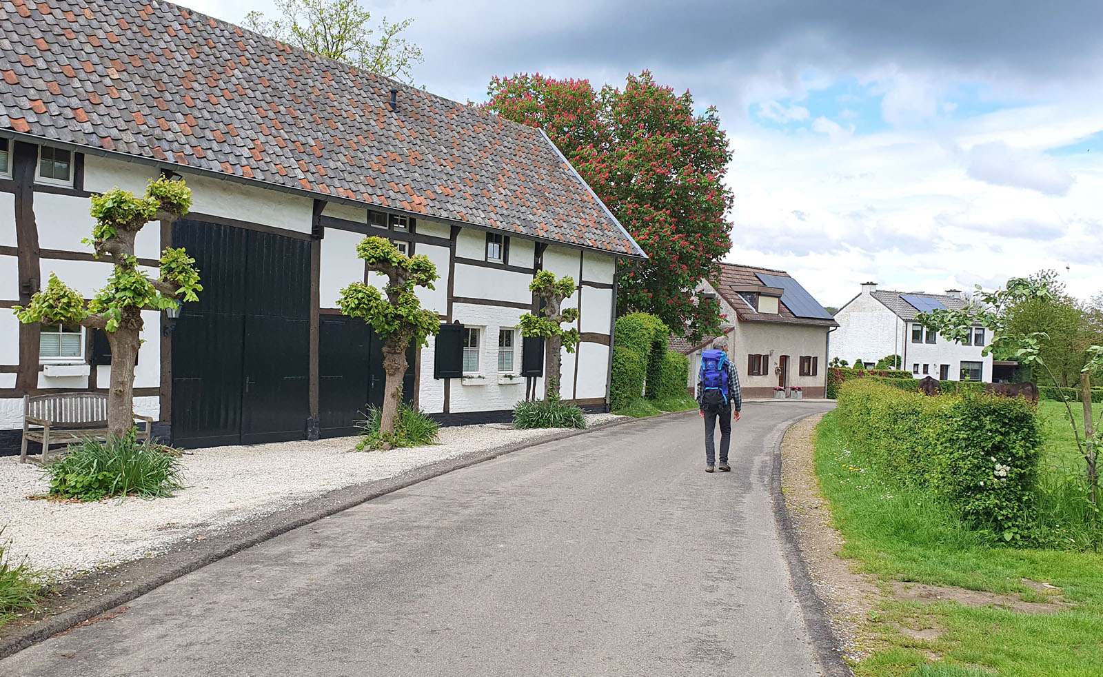 wandelaar langs vakwerkhuis in Limburg.