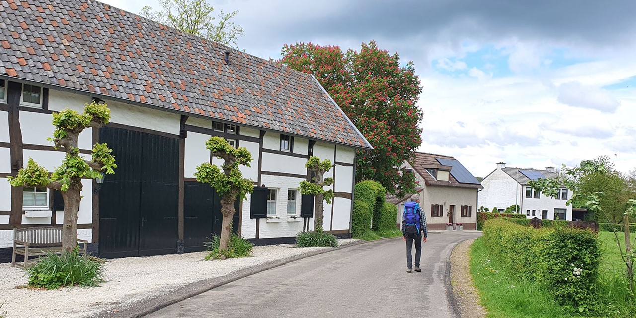 wandelaar langs vakwerkhuis in Limburg.