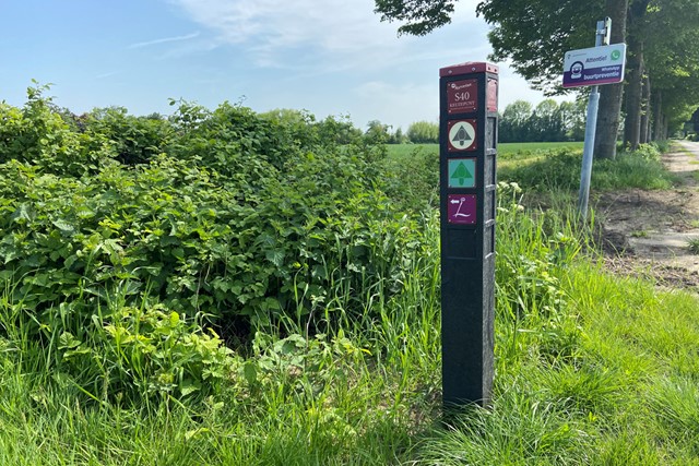 paal met markeringen van wandelpaden.
