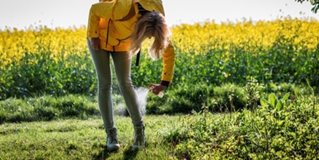 Vrouw die DEET spuit