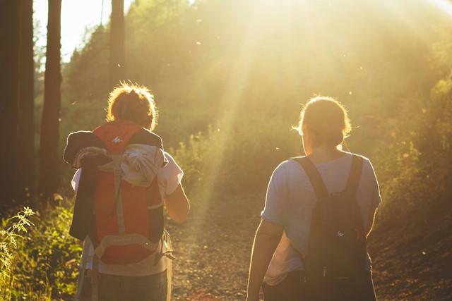 Praten tijdens het wandelen, twee mensen die samen wandelen in diffuus zonlicht