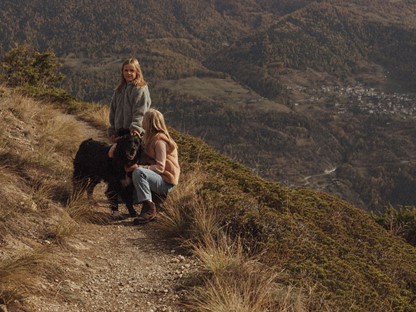 vrouw, meisje en hond in de bergen.