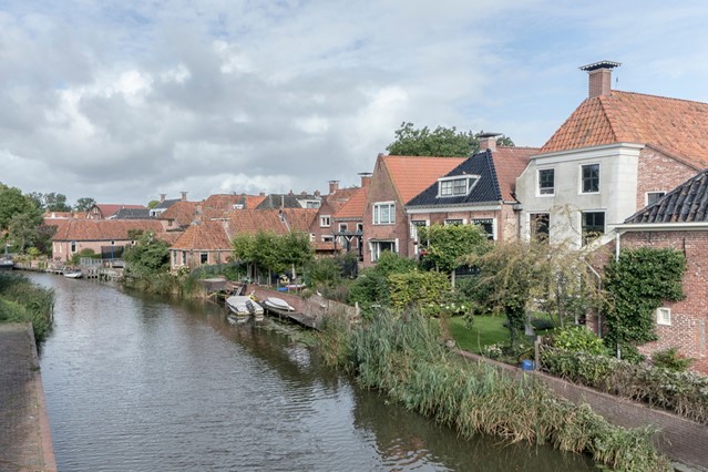 afbeelding van oude huisjes aan het water in Winsum.