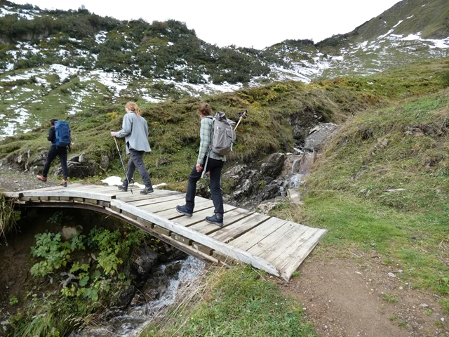 afbeelding van wandelaars die over een bruggetje lopen.