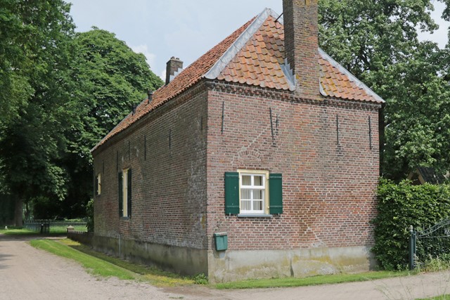 een bakstenen gebouw met een raam met een luikje en een schoorsteen