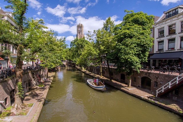 afbeelding van een Utrechtse gracht met een bootje en de Domkerk
