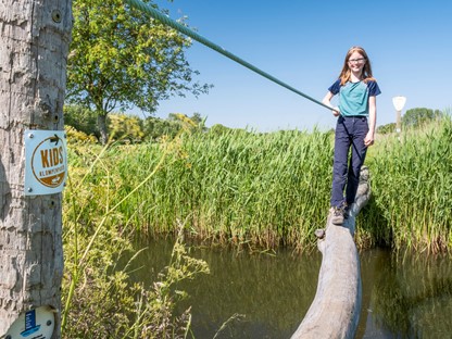Agnes wandelt op een boomstronk op het Niebroekerpad KIDS