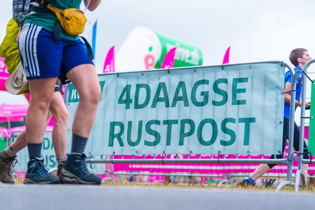 wandelaars tijdens de 4Daagse lopen langs de KWbN 4Daagse Rustpost.