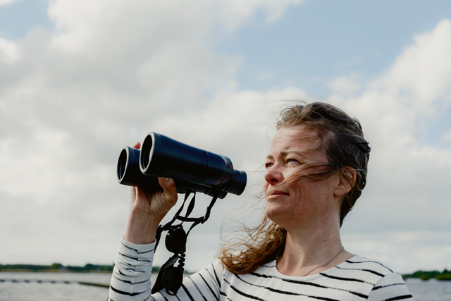 Wandelaar met een verrekijker is vogels aan het spotten