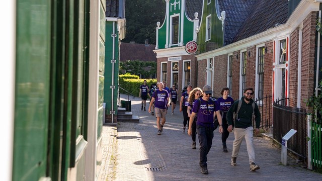 Deelnemers aan de Mega Wandel Marathon wandelen door een OudHollands straatje