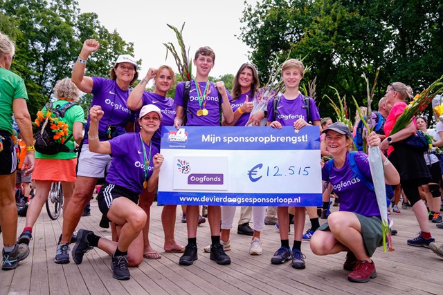 een groep 4Daagselopers met een cheque van de opbrengst voor de Oogfonds in hun handen.