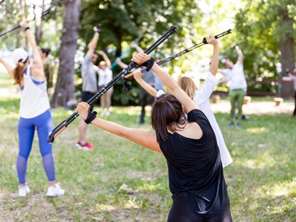 afbeelding van een groep mensen die aan het trainen zijn met Nordic Walking stokken.