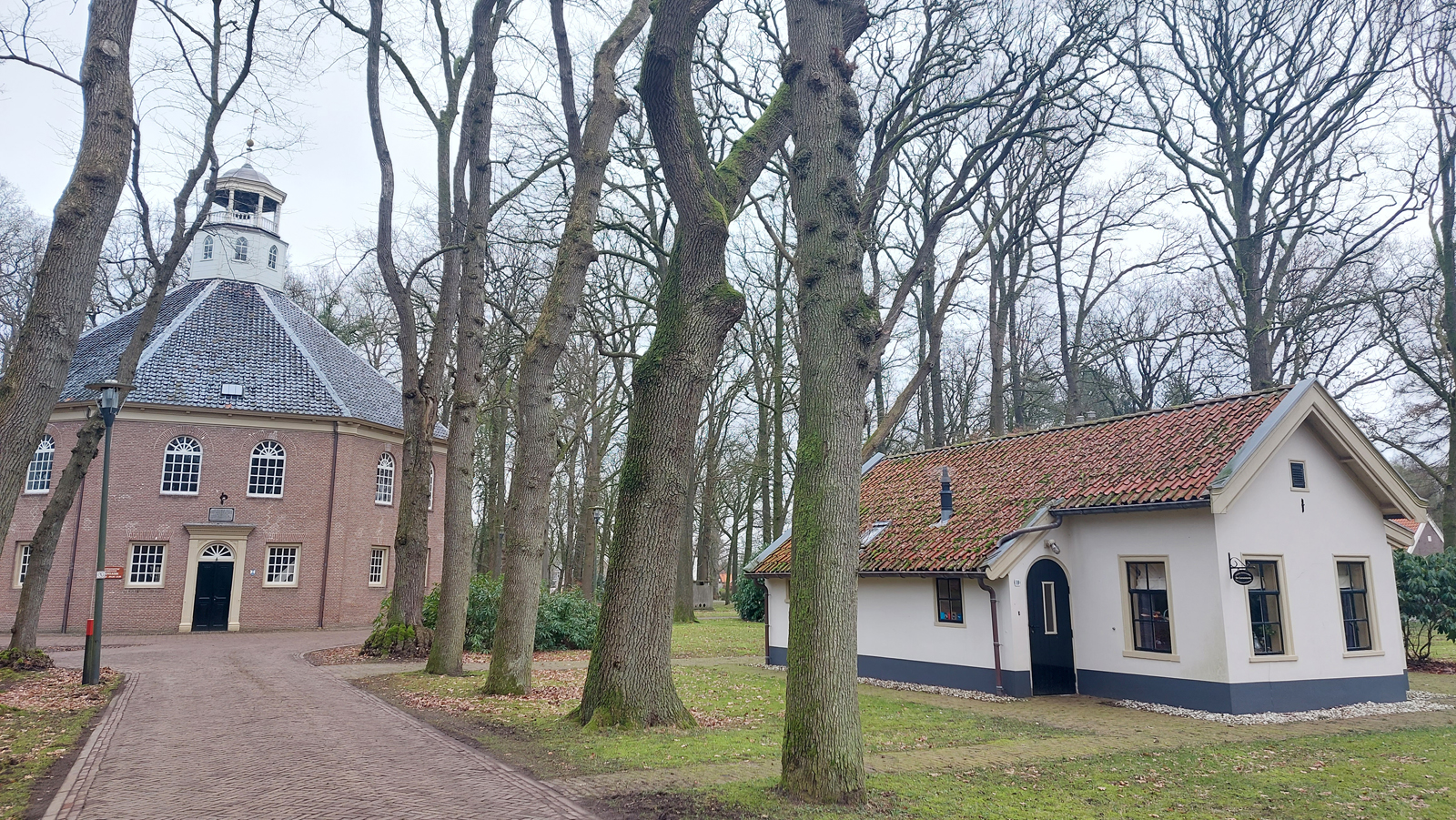afbeelding van de Koepelkerk en een wit huisje ernaast.