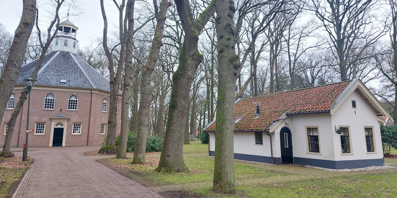 afbeelding van de Koepelkerk en een wit huisje ernaast.