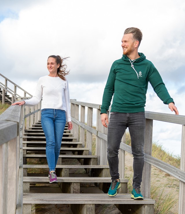 afbeelding van een vrouw en man die wandelen op een houten trap.