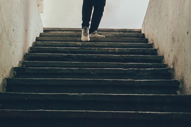 afbeelding van iemand die een trap af loopt.