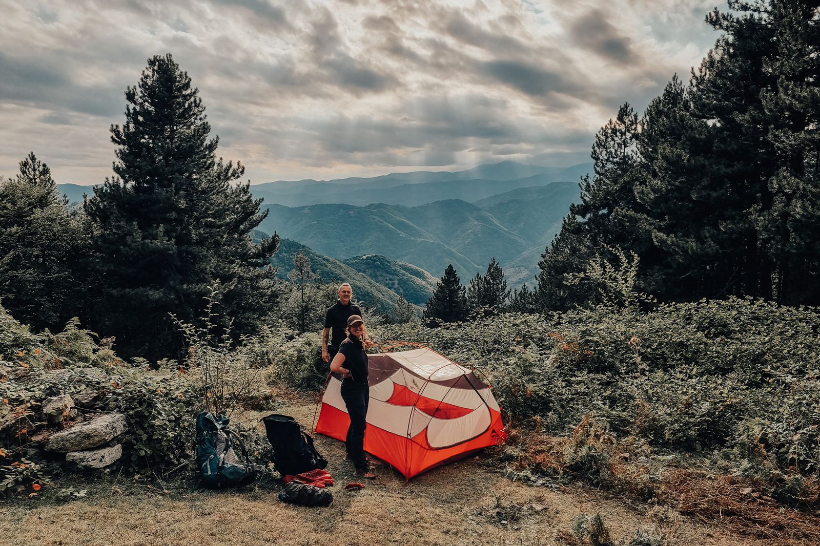 twee wandelaars zetten een tent op in de bergen.