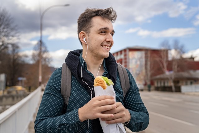 afbeelding van een wandelaar die een broodje gezond eet.