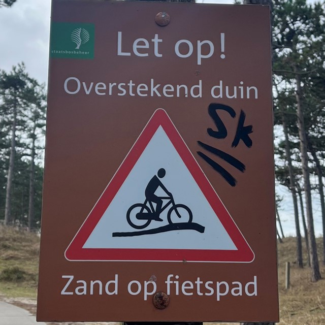 Bordjes en markeringen tijdens het wandelen; overstekend duin;