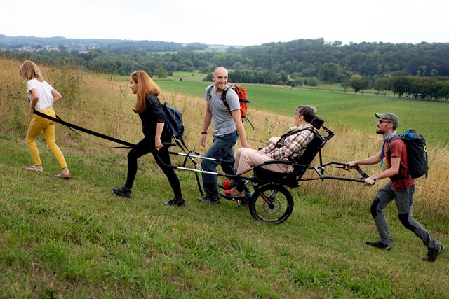 afbeelding van wandelaars met een Joélette (wandelvoertuig)