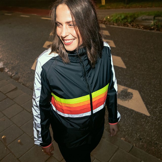 afbeelding van een vrouw in een GoFluo jasje in het donker.